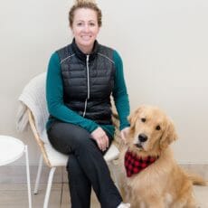 Managing partner of a veterinary clinic sitting with a golden retriever